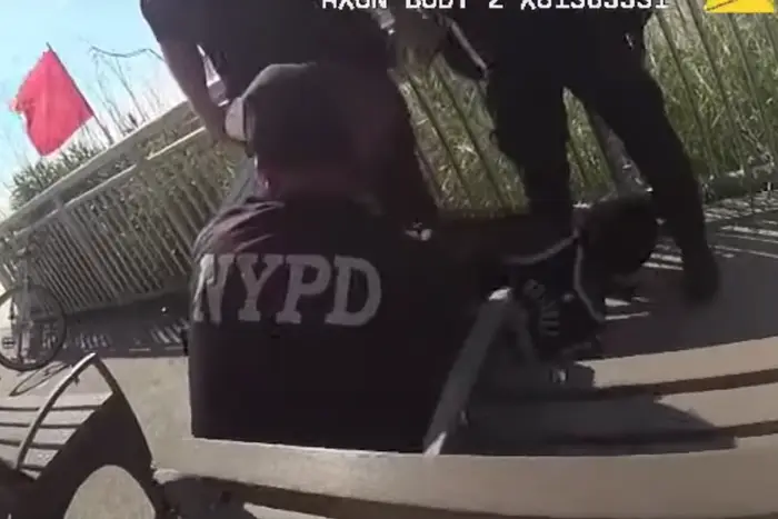 A screenshot from body camera footage of officers holding the man down.
